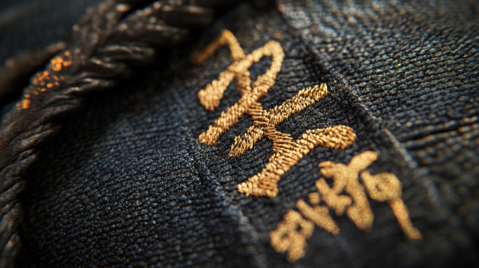 Close-up of gold-thread embroidery on dark velvet